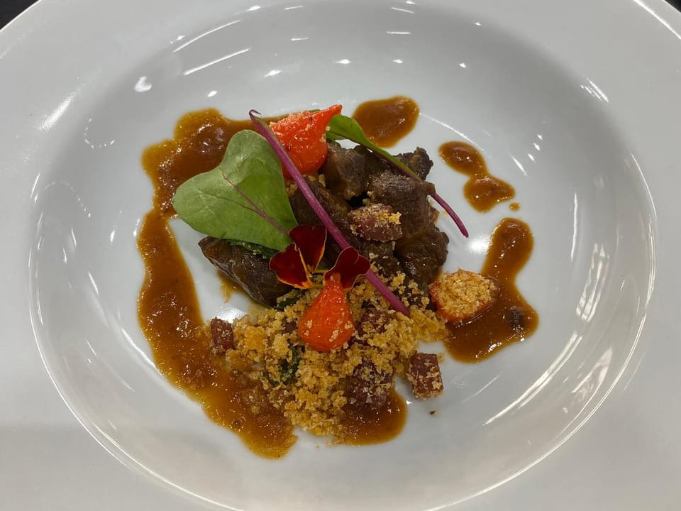 Plato principal: estofado con crumble crujiente y pétalos cítricos.