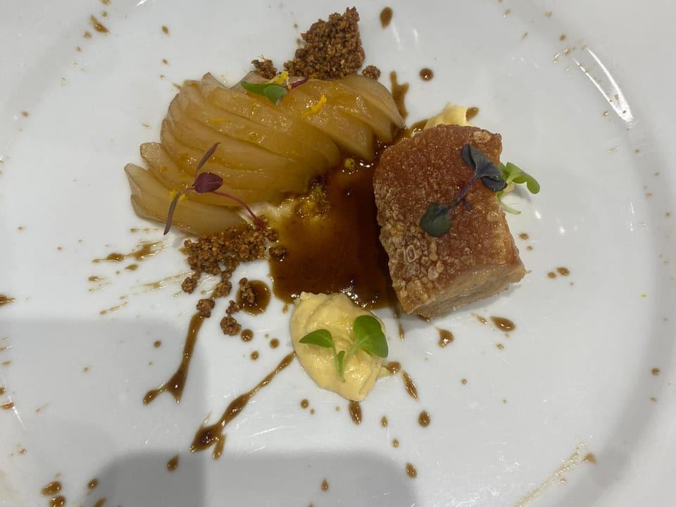 Plato principal: panceta crujiente con compota de pera y crumble de cacao.